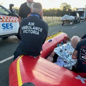 Rescuers with the woman Mitchell Smith saved from floodwater.