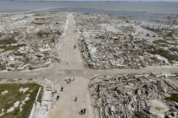 Tourists walk along the main street of the abandoned Villa Epecuen, Argentina.
