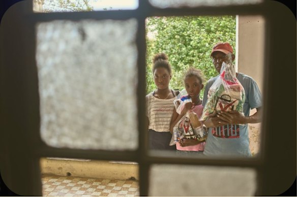 A recipient of Mexican humanitarian aid with his daughters at their home in Havana in February.