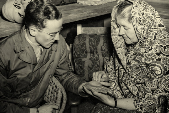 A “fortune-teller” reads a soldier’s  palm at a Halloween party in Australia in 1943.