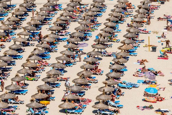Tourist sunbathe at Magaluf beach in Mallorca, Spain.