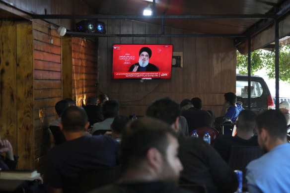 People watch a speech by Hezbollah leader Hassan Nasrallah on a TV screen  in a cafe in the southern suburbs of Beirut last week.