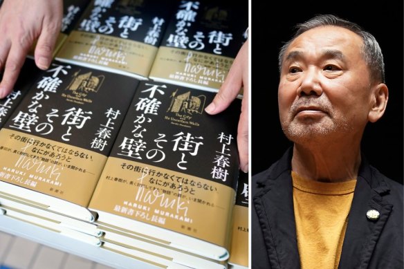 A shop clerk arranges copies of The City and Its Uncertain Walls by Haruki Murakami (right) on the first day for sale at Kinokuniya bookstore in Shinjuku.
