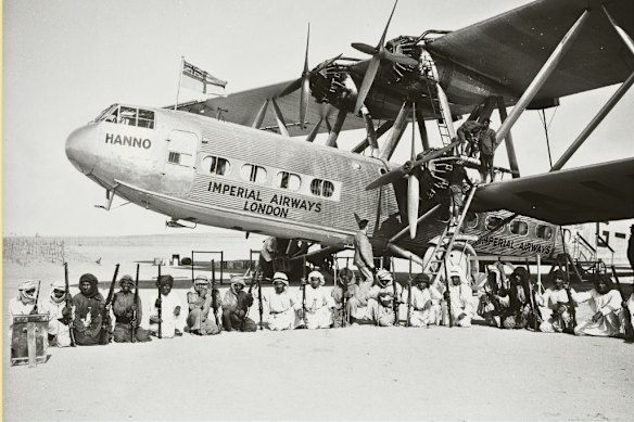 An Imperial Airways plane surrounded by an armed guard from the Sheikh of Sharjah during a refuelling stop at Sharjah Airport in the Trucial States in 1934.  