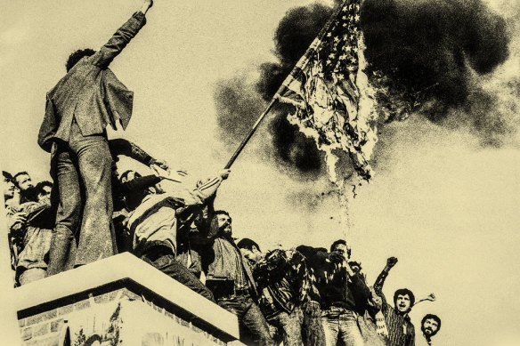 Protesters perched on a wall of the US embassy in Tehran burn an American flag during the hostage crisis of 1979. 