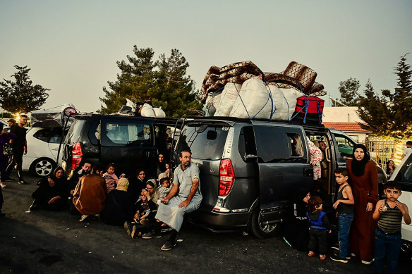 Lebanese families escaping airstrikes at a border crossing into Syria. 