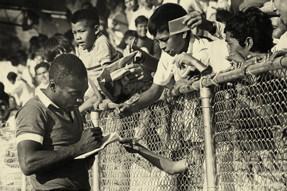 Brazilian footballer Pele, born Edson Arantes do Nascimento, signs autographs in 1970. 