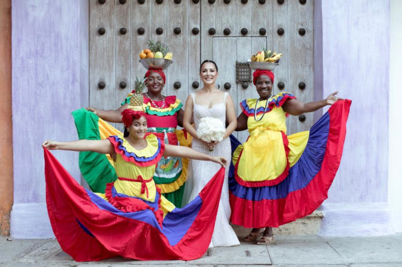 Sandra Cabrera poses with dancers in her Colombian homeland before marrying grocery heir Luke Harris.
 