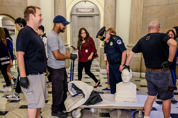 Workers move a bust of John Quincy Adams through the Capitol during renovations to the building in 2019.