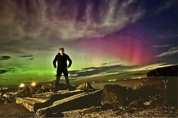 Astrophotography enthusiast Justin Baker in a self-portrait with the Aurora Australis, or Southern Lights. 