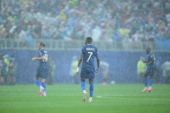 Ousmane Dembele stands in the rain during France’s game against Iraq.