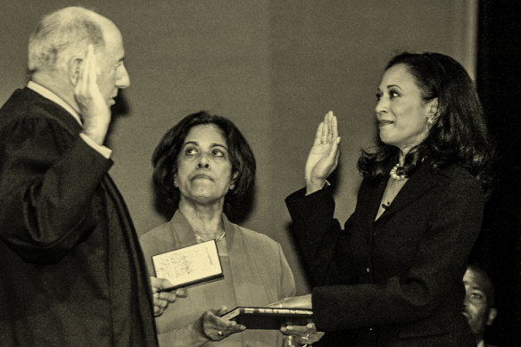 Harris, right, is sworn in as district attorney of California in 2004 as her mother, Shyamala, holds a copy of the US Bill of Rights. 