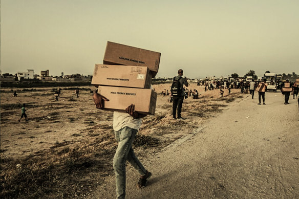 A Palestinian carries food aid boxes from the UN World Food Programme in central Gaza, on May 18.
