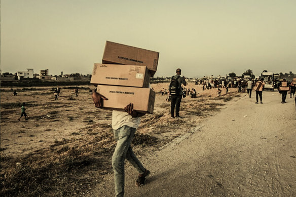 A Palestinian carries food aid boxes from the UN World Food Programme in central Gaza, on May 18.
