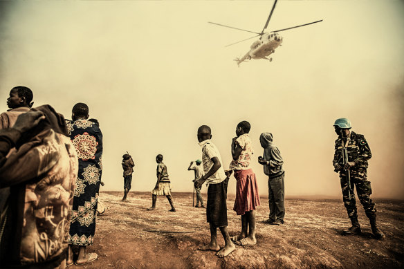 Displaced people watch a UN helicopter land with the Under-Secretary-General for Peace Operations Jean Pierre Lacroix in eastern Congo in 2022. 