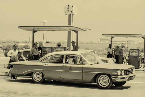 In Kuwait in 1963, an American car gets filled up by uniformed assistants at a petrol station. By this time, the nation was already sitting on a sovereign nest egg. 