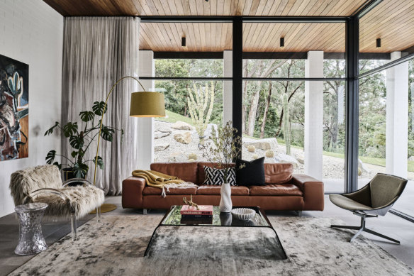 Floor-to-ceiling windows bring the outdoors in the light-filled living room.