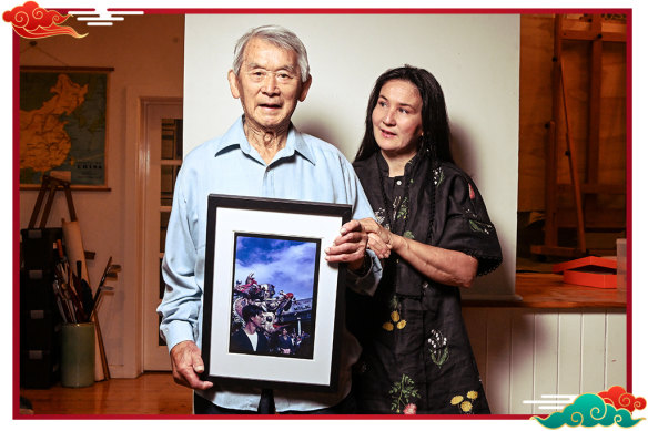 Russell Jack (holding a photo of himself as a young man during a dragon parade) and daughter Anita.