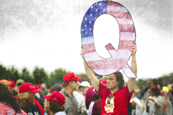 A Donald Trump supporter holds up a QAnon sign at a rally in 2018. 