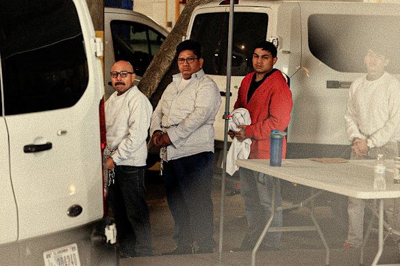 Immigrant detainees are cuffed and walked to vans on June 7 in Los Angeles.