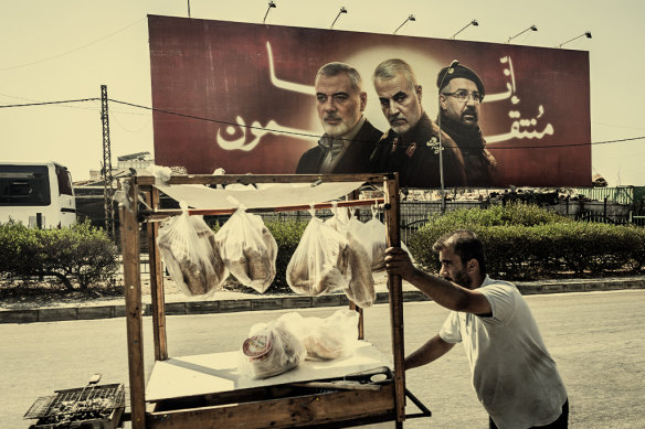 In Lebanon’s capital Beirut, a food cart vendor passes a billboard showing assassinated leaders Hamas’s Ismail Haniyeh, General Qasem Soleimani of the Iranian Revolutionary Guard and Hezbollah commander Fuad Shukr.