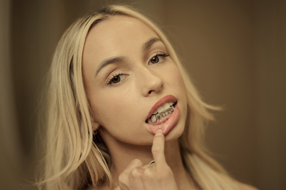“Grillz”, especially gold and diamonds, are a trend. Saskia, a client of dentist Maheer Shah, shows off hers.  