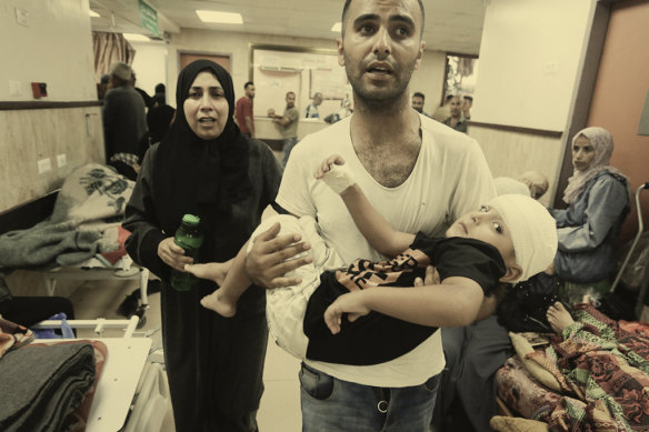 In Gaza, an injured child is carried through a hospital after an Israeli army bombing in August. 