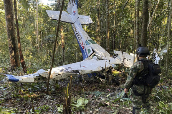 Bir asker, Kolombiya'nın Caqueta eyaletindeki Solano ormanına düşen Cessna C206'nın enkazının önünde duruyor.