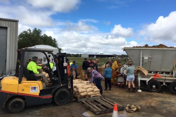 Locals fill sandbags in Hay on Tuesday morning, in an effort to keep the rising Murrumbidgee River out of their town.