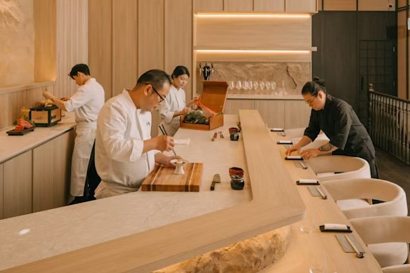 No balcão omakase curvo do Sushi Sho, os chefs cortam à mão e servem 10 pratos de sushi por sessão.