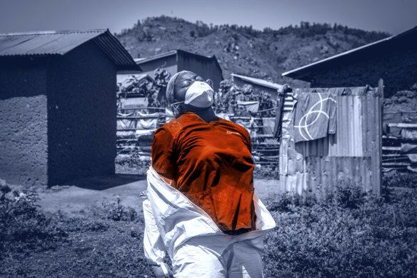 A WHO worker in the Congo removes her protective outfit after decontaminating the house of a pastor with Ebola in June 2019.