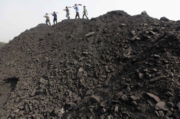 Workers walk on a heap of coal at a mine in the Mahanadi coal fields, India. Almost 40 per cent of India’s electricity already comes from renewables but talk of a just transition is only starting to break through into the energy debate there, spurred on in part by health concerns over poor working conditions for miners.