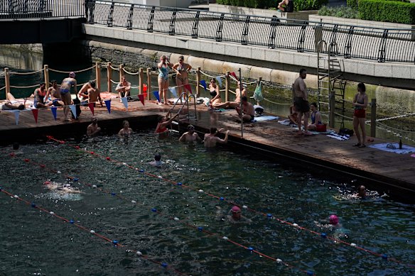 People swim in an outdoor pool in London on Tuesday.