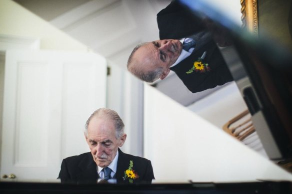 Raymond Fischer reflected in the lid of his grand piano.