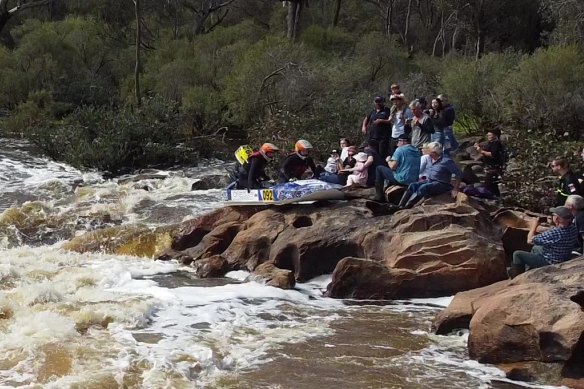 The powerboat slid up on rocks and narrowly missed spectators – including a small child – as it attempted to navigate the Super Chute rapids.