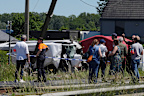 Police and residents gather around a level crossing where a train collided with a minibus in Buggenhout, Belgium, on Tuesday, May 26, 2026.