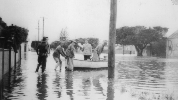 People get into a boat to escape the flood waters.