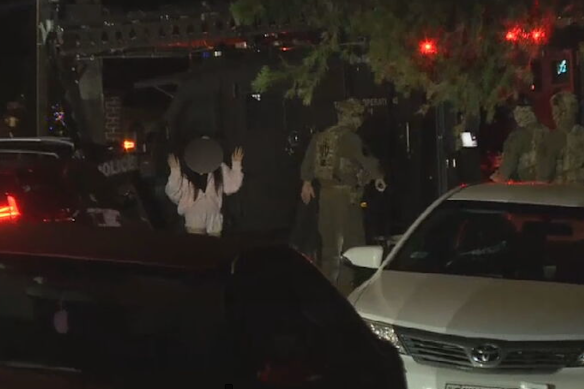 An occupant of the Fairfield West home leaves the address with hands raised.