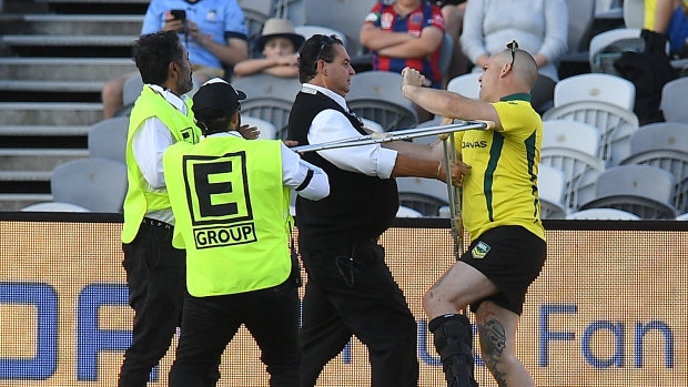 Hobbled: A pitch invader is removed by security at Central Coast Stadium.