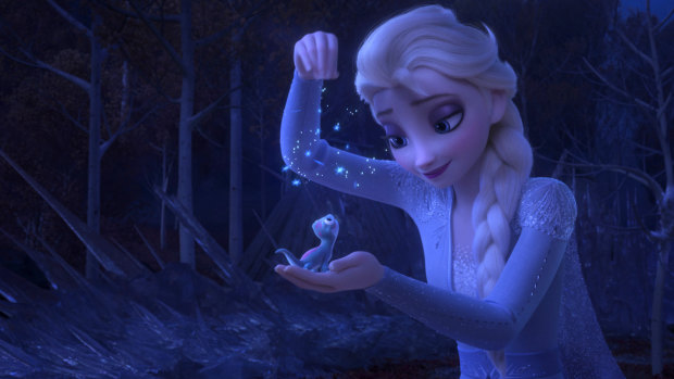 Elsa, voiced by Idina Menzel, sprinkling snowflakes on a salamander named Bruni in Frozen II.