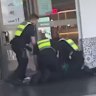 Police officers apprehend a person at Northland after Sunday’s brawl.