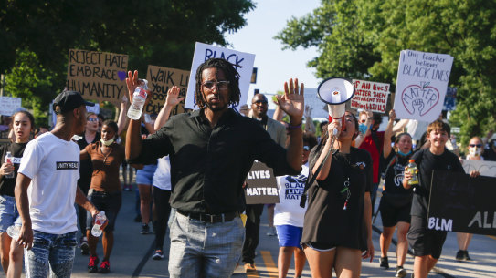 Joshua Benton leads protesters as they march down Main Street during a rally in Broken Arrow, Oklahoma. 