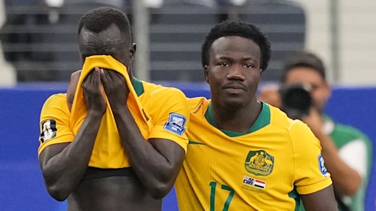 O australiano Nestory Irankunda abraça o companheiro de equipe Awer Mabil após a derrota.