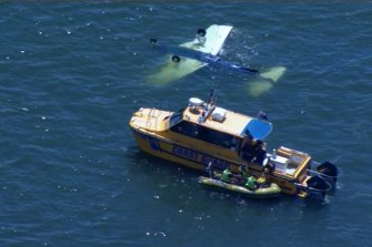 The coastguard at the scene of the semi-submerged plane off Redcliffe on Sunday morning.