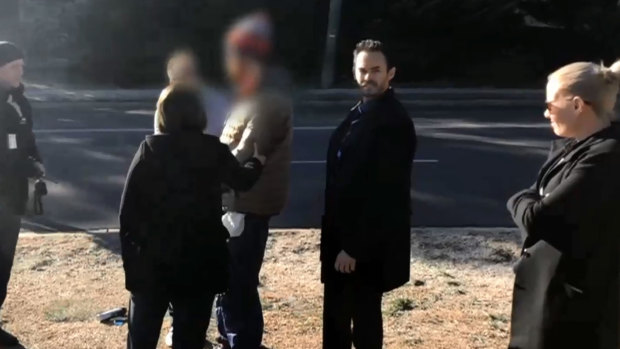 Police arrest a man (with his face blurred) in Jindabyne on Tuesday over the alleged sexual assault of a woman and the assault of a man.