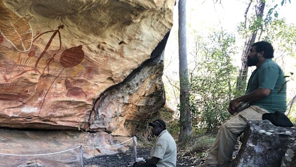 Visitor Clarry Nadjamerrek (seated) looking at Quinkan art in the Giant Horse site.