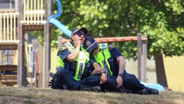 Police officers comfort each other at Hillcrest Primary School in Devonport on Thursday.