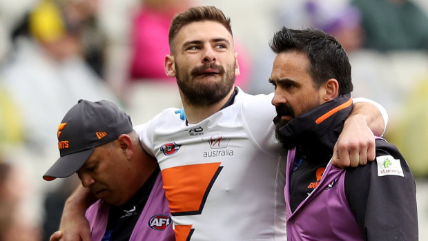 Giants star Stephen Coniglio is helped from the field on Sunday. 