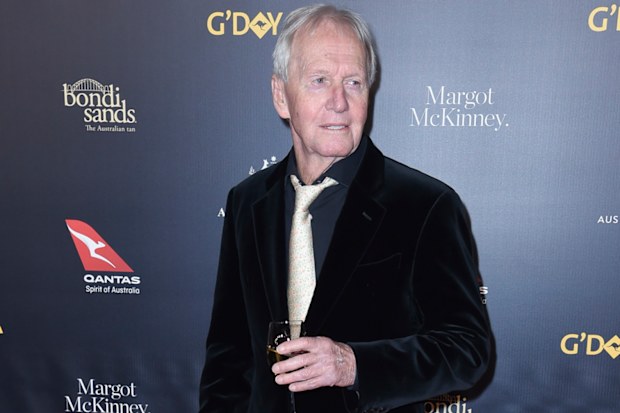 Paul Hogan on the red carpet with white wine in hand.