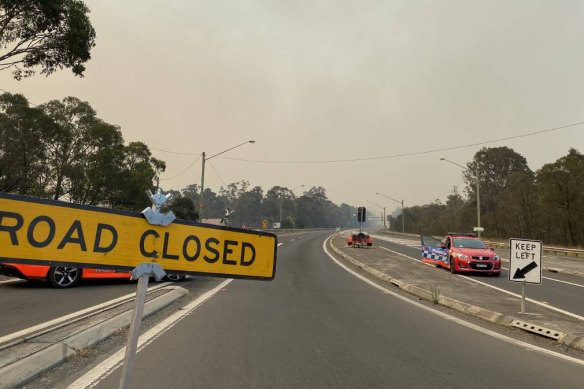 Smoke rises from the Comberton fire in the background of a road closure on the Princes Highway.